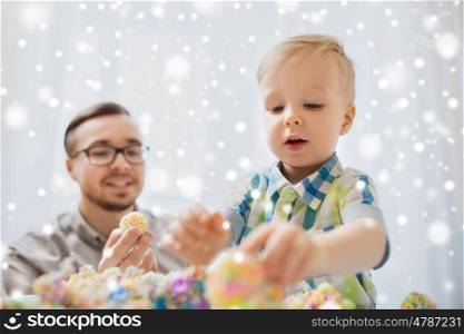 family, childhood, creativity, activity and people concept - happy father and little son playing with ball clay at home over snow