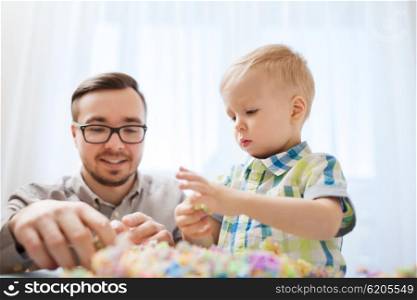 family, childhood, creativity, activity and people concept - happy father and little son playing with ball clay at home