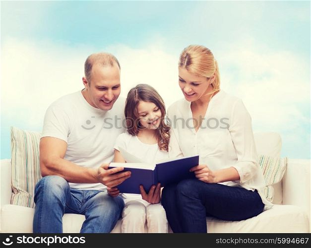 family, childhood, dream and people - smiling mother, father and little girl reading book over blue sky background