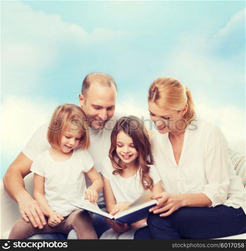family, childhood, dream and people - smiling mother, father and little girls reading book over blue sky background