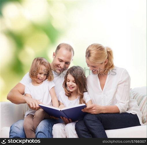 family, childhood, ecology and people - smiling mother, father and little girls reading book over green background