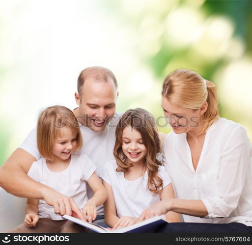 family, childhood, ecology and people - smiling mother, father and little girls reading book over green background