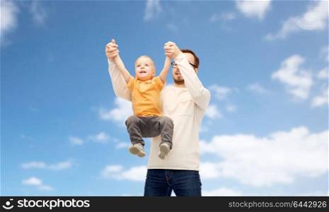family, childhood, fatherhood and people concept - happy father and little son playing and having fun over blue sky and clouds background. father with son playing and having fun