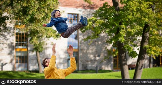 family, childhood, fatherhood, leisure and people concept - happy father and little son playing and having fun outdoors over summer city yard background