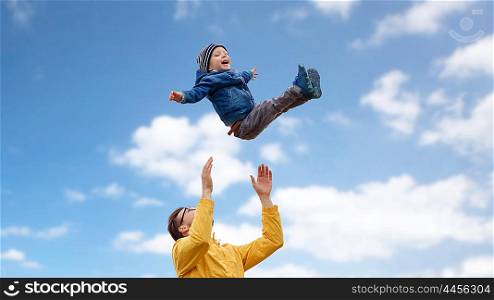 family, childhood, fatherhood, leisure and people concept - happy father and little son playing and having fun over blue sky and clouds background
