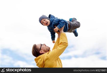 family, childhood, fatherhood, leisure and people concept - happy father and little son playing and having fun outdoors