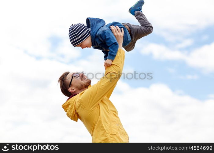 family, childhood, fatherhood, leisure and people concept - happy father and little son playing and having fun outdoors