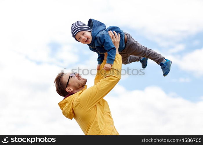 family, childhood, fatherhood, leisure and people concept - happy father and little son playing and having fun outdoors