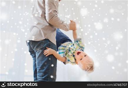 family, childhood, fatherhood, leisure and people concept - happy father and little son playing and having fun at home over snow