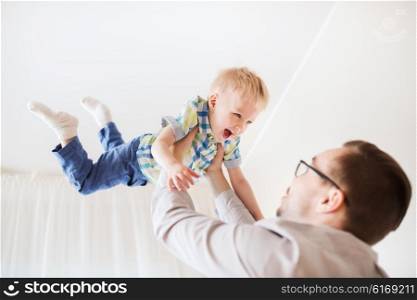 family, childhood, fatherhood, leisure and people concept - happy father and little son playing and having fun at home