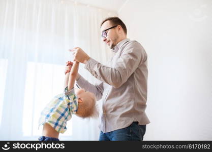 family, childhood, fatherhood, leisure and people concept - happy father and little son playing and having fun at home