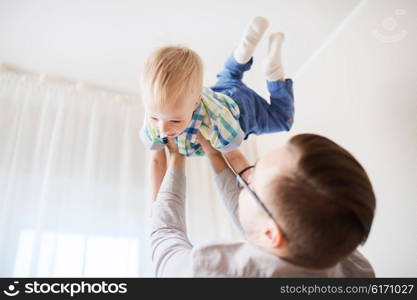 family, childhood, fatherhood, leisure and people concept - happy father and little son playing and having fun at home