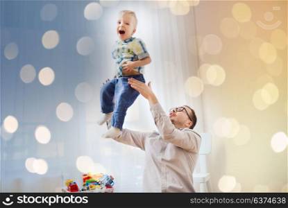 family, childhood, fatherhood, leisure and people concept - happy father and little son playing and having fun at home. father with son playing and having fun at home