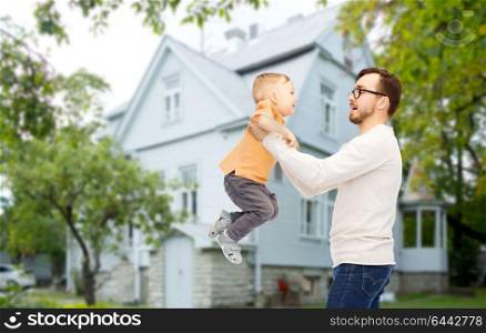 family, childhood, fatherhood, leisure and people concept - happy father and little son playing and having fun over house background. father with son playing and having fun