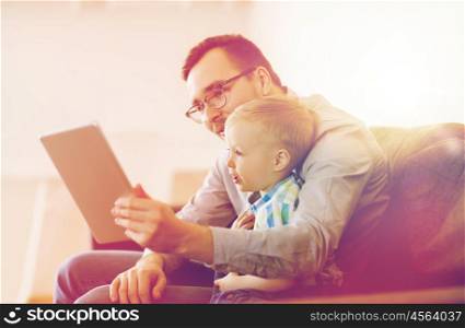 family, childhood, fatherhood, technology and people concept - happy father and son with tablet pc computer playing or having video chat at home