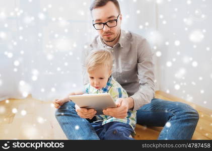 family, childhood, fatherhood, technology and people concept - happy father and son with tablet pc computer playing at home over snow