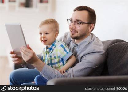 family, childhood, fatherhood, technology and people concept - happy father and son with tablet pc computer playing or having video chat at home