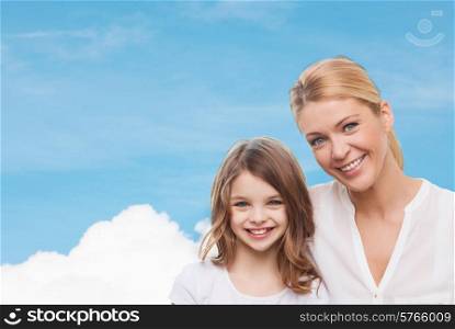 family, childhood, happiness and people - smiling mother and little girl over blue sky and white cloud background