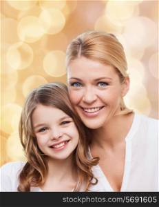 family, childhood, happiness and people - smiling mother and little girl over beige lights background