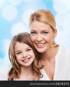 family, childhood, happiness and people - smiling mother and little girl over blue lights background