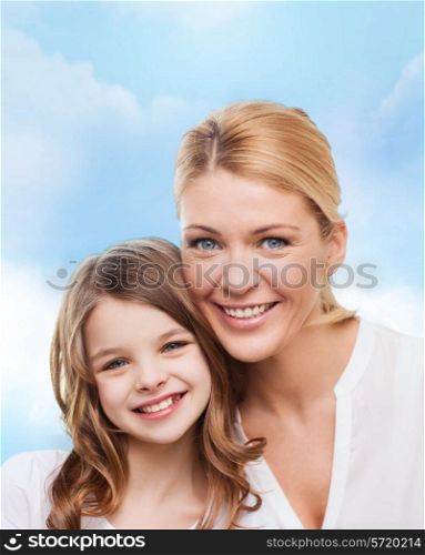 family, childhood, happiness and people - smiling mother and little girl over blue sky background