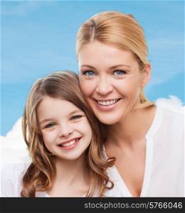 family, childhood, happiness and people - smiling mother and little girl over blue sky background