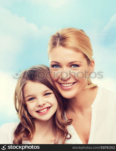 family, childhood, happiness and people - smiling mother and little girl over blue sky background