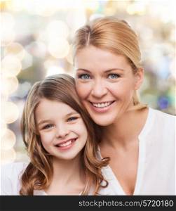 family, childhood, happiness and people - smiling mother and little girl over lights background
