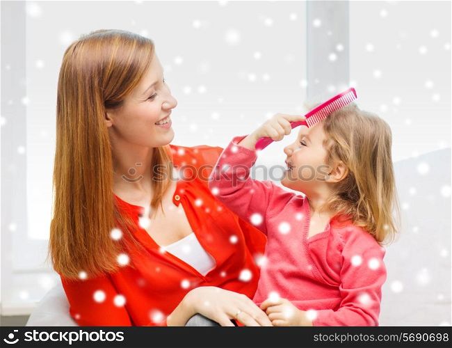 family, childhood, holidays and people concept - happy mother and daughter with comb at home