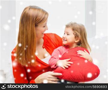family, childhood, holidays and people concept - happy mother and daughter with with heart shape pillow