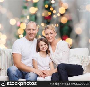 family, childhood, holidays and people concept - smiling mother, father and little girl over christmas tree lights background