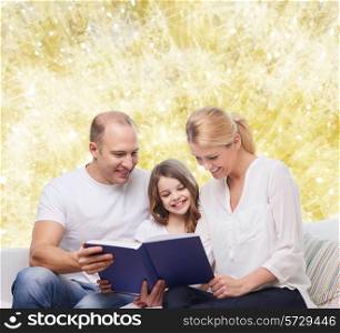 family, childhood, holidays and people - smiling mother, father and little girl reading book over yellow lights background