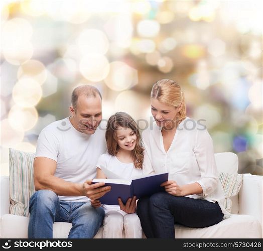family, childhood, holidays and people - smiling mother, father and little girl reading book over lights background