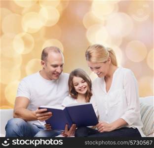 family, childhood, holidays and people - smiling mother, father and little girl reading book over beige lights background