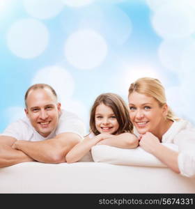 family, childhood, holidays and people - smiling mother, father and little girl over blue lights background