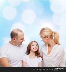 family, childhood, holidays and people - smiling mother, father and little girl over blue lights background
