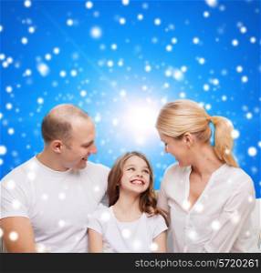 family, childhood, holidays and people - smiling mother, father and little girl over blue snowy background