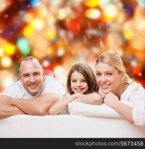 family, childhood, holidays and people - smiling mother, father and little girl over red lights background