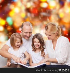 family, childhood, holidays and people - smiling mother, father and little girls reading book over red lights background