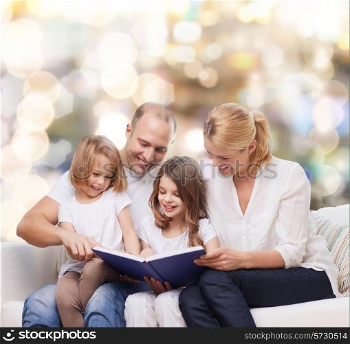 family, childhood, holidays and people - smiling mother, father and little girls reading book over lights background