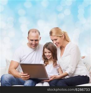 family, childhood, holidays, technology and people concept - smiling family with laptop computer over blue lights background