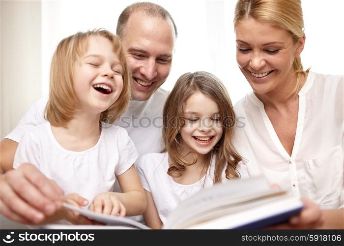 family, childhood, literature and people - happy mother, father and little girls reading book and laughing at home