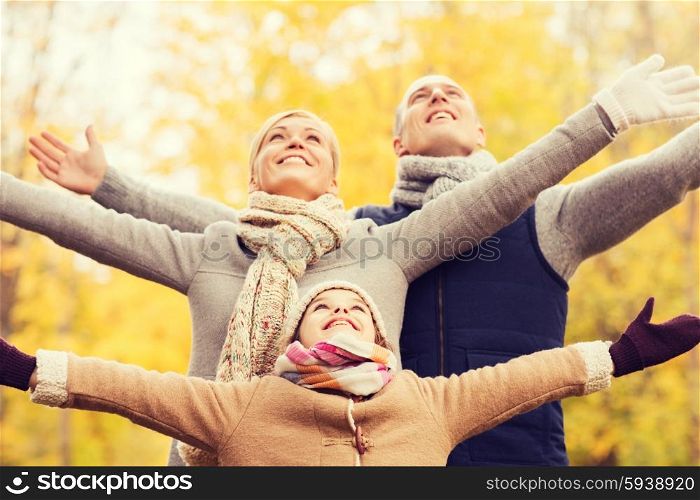 family, childhood, season and people concept - happy family having fun in autumn park