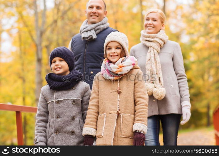 family, childhood, season and people concept - happy family in autumn park