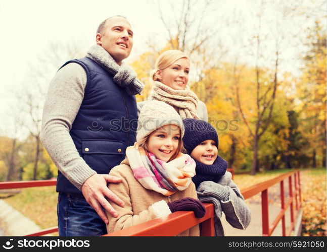 family, childhood, season and people concept - happy family in autumn park