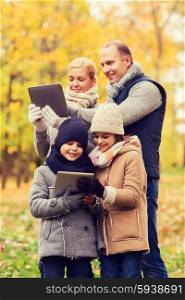 family, childhood, season, technology and people concept - happy family with tablet pc computers in autumn park