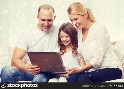 family, childhood, technology and people concept - smiling family with laptop computer over snowflakes background