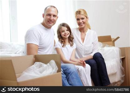 family, children, accommodation and people concept - happy family with boxes moving to new home