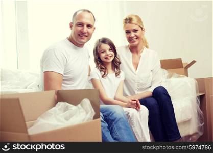 family, children, accommodation and people concept - happy family with boxes moving to new home