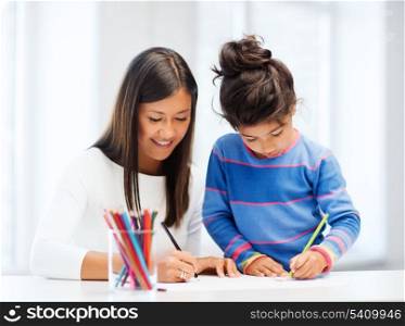 family, children and happy people concept - mother and daughter drawing